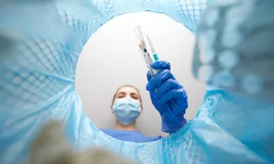 doctor throwing used syringes into trash can