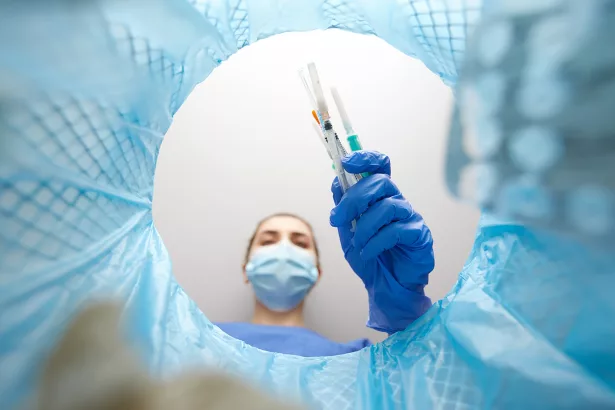 doctor throwing used syringes into trash can