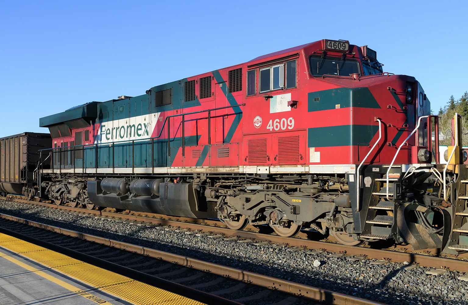 Ferromex locomotive working a train in the United States against a blue sky with no people