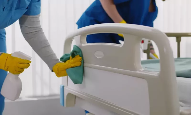 Team of professional janitors using equipment disinfecting hospital ward