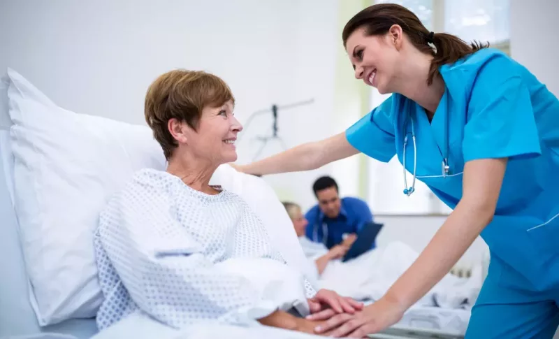 Nurse consoling a patient in hospital ward