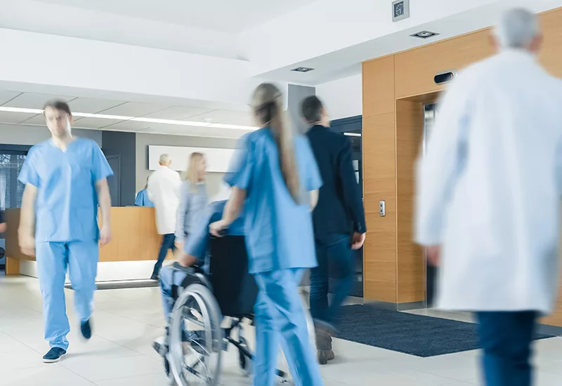 Hospital Lobby. Doctors, Nurses, Assistant Personnel and Patients Working and Walking in the Lobby of the Medical Facility.