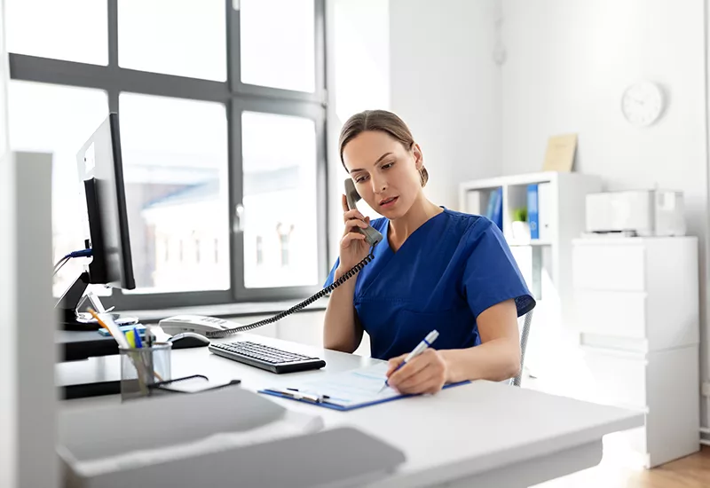 doctor with computer calling on phone at hospital
