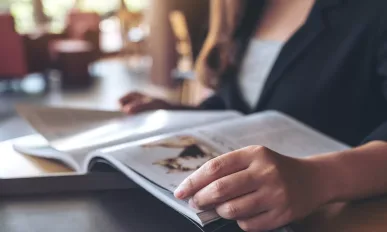 Closeup image of a business woman reading a book in modern cafe
