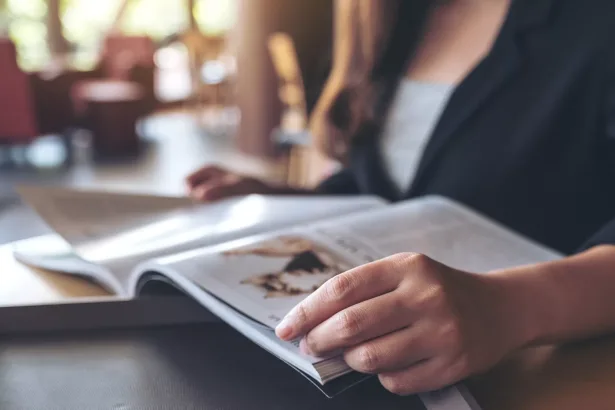 Closeup image of a business woman reading a book in modern cafe