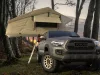 Toyota Tacoma with a tent at a forest camp